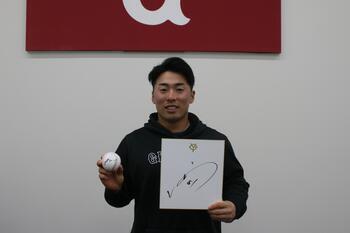 Photo: Player Asano holding a signed color paper and a ball