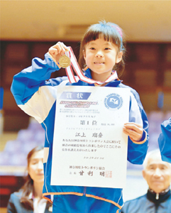 Photo: Egami holding a medal and a certificate