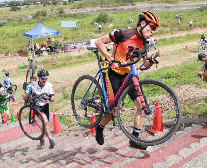 Photo: A competitor carrying a bicycle up the stairs