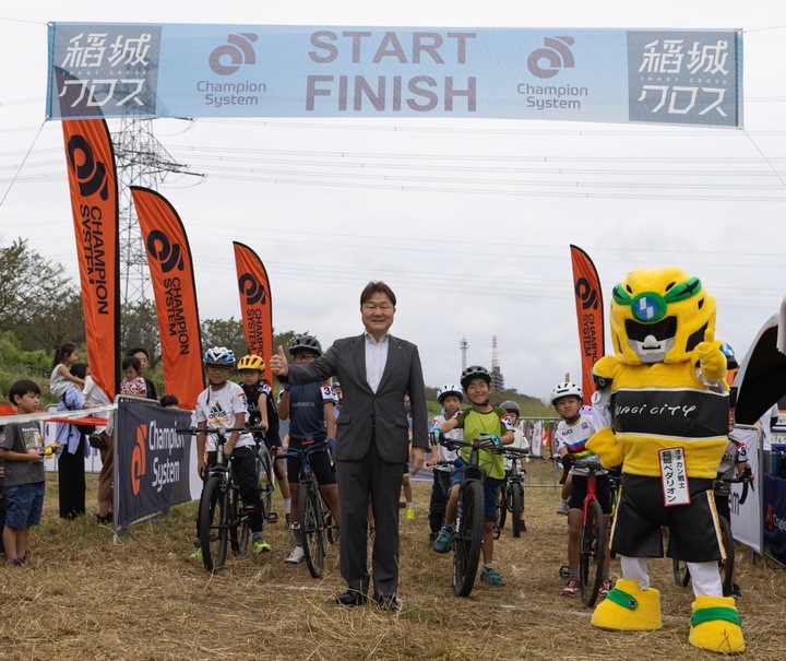 Group photo of the children participating in the race, the Mayor of Inagi, and Pedalion at the starting point