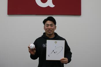 Photo of Asano holding his autograph