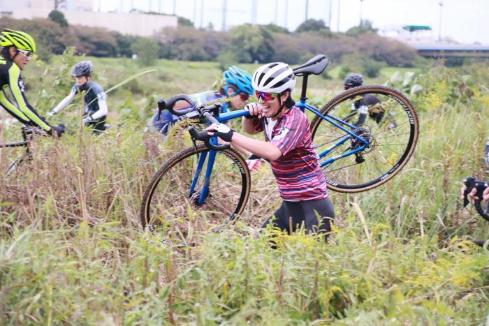 Foto: Atleta carregando a bicicleta enquanto corre